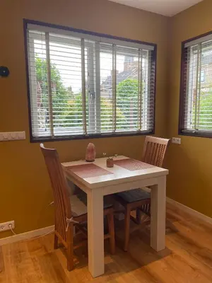 a dining room with a table and chairs and windows at Bed & Breakfast Danina in Sassenheim
