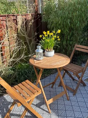 a wooden table with two chairs and a table with flowers at Bed & Breakfast Danina in Sassenheim