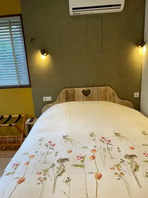 a bed with a blanket with flowers on it at Bed & Breakfast Danina in Sassenheim
