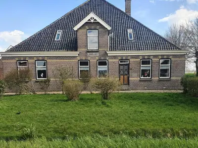 a large brick house with a gambrel roof at Landlust in Purmerend