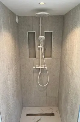 a shower with a shower head in a bathroom at Aventure, beach 500m, free parking in Noordwijk