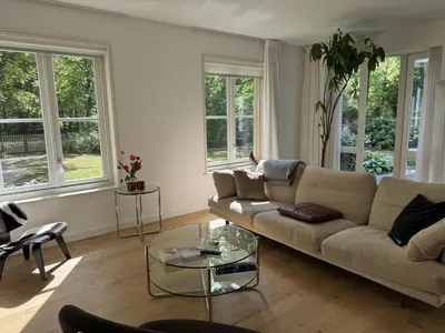 a living room with a couch and a glass table at Het Bosch in Bergen