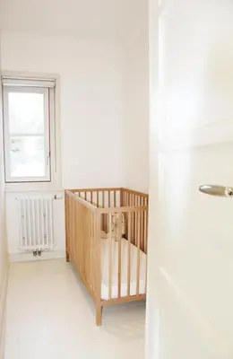 a baby crib in a room with a window at Het Bosch in Bergen