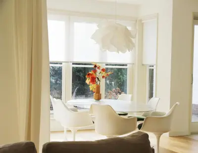 a dining room with a white table and white chairs at Het Bosch in Bergen