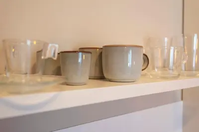 a row of glass cups sitting on a shelf at Kings Square in Zandvoort