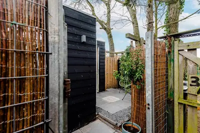 an entrance to a garden with a black fence at The Garden Suite in Zandvoort