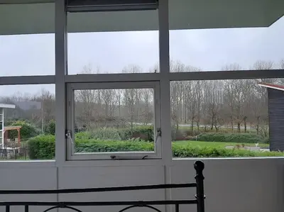a window in a room looking out at a garden at Gastehuisie Lekkerslaap in Zeewolde