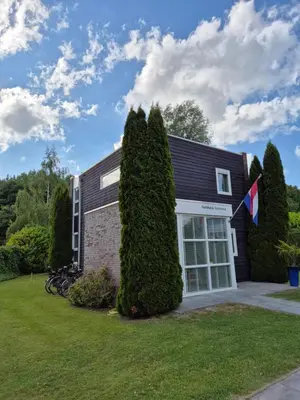 a house with a large bush in front of it at Gastehuisie Goedemoed in Zeewolde