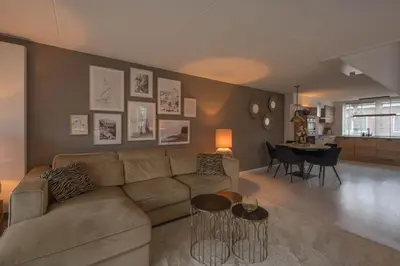 a living room with a couch and a table at Meerzicht 99 - Luxury house 30 minutes from Amsterdam in Uitgeest