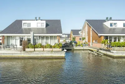 a row of houses next to a body of water at Meerzicht 99 - Luxury house 30 minutes from Amsterdam in Uitgeest