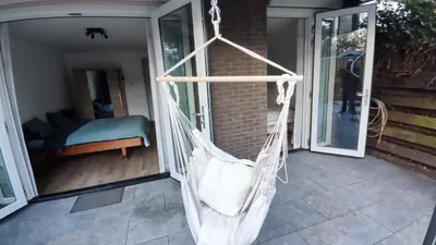 a hammock on the porch of a house at B&B Sabai Sabai Amsterdam in Amsterdam