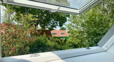 an open window with a view of a house at Smederij Abbekerk, guesthouse in Abbekerk