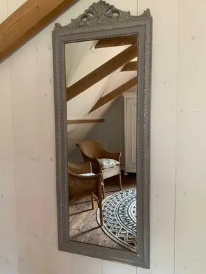 a mirror on a wall with a chair in a room at Smederij Abbekerk, guesthouse in Abbekerk