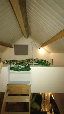 a room with a bed in a attic at Tuinhuisje in het groen in Almere