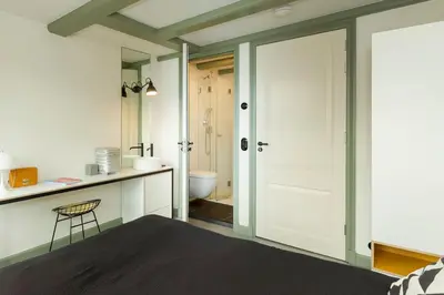 a bedroom with a door leading to a bathroom at The Red Ox - Super Central Canal View Rooms in Amsterdam
