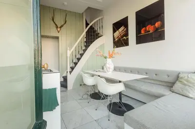 a living room with a table and a staircase at The Red Ox - Super Central Canal View Rooms in Amsterdam