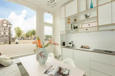 a kitchen with a vase with flowers on a table at The Red Ox - Super Central Canal View Rooms in Amsterdam
