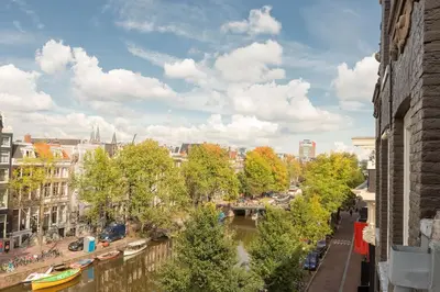 a view of a city with a river and buildings at The Red Ox - Super Central Canal View Rooms in Amsterdam