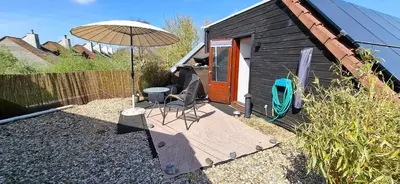 a patio with an umbrella and a table and chairs at StudioRandijk in Nieuwegein