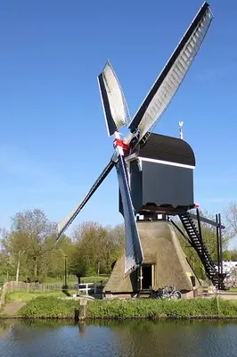 a windmill sitting in the middle of a body of water at StudioRandijk in Nieuwegein