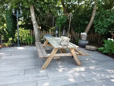 a wooden picnic table with a swing on a patio at BenB Humblebee met jaccuzi in Alkmaar