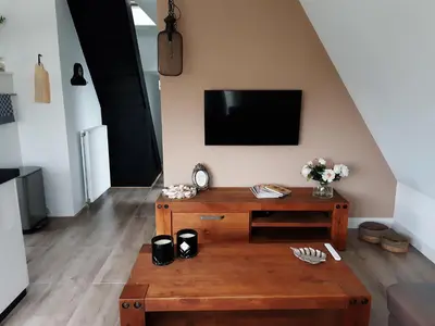 a living room with a wooden table and a tv at BenB Humblebee met jaccuzi in Alkmaar