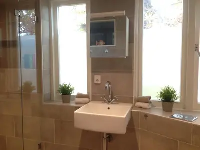 a bathroom with a sink and a mirror and windows at De Lijster in Bergen