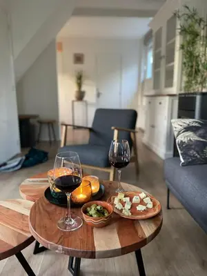 a table with two glasses of wine and food on it at De Lijster in Bergen