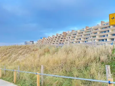 a large apartment building on the side of a beach at Amstel BeachHouse Egmond aan Zee, 50m from the beach! in Egmond aan Zee