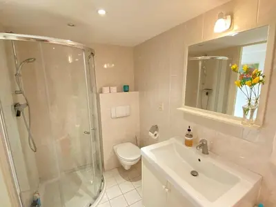 a bathroom with a shower and a sink and a toilet at Amstel BeachHouse Egmond aan Zee, 50m from the beach! in Egmond aan Zee