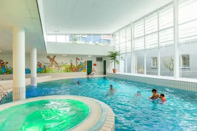 a pool in a building with people in the water at Marinapark Volendam in Volendam