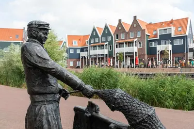 a statue of a man holding a child at Marinapark Volendam in Volendam