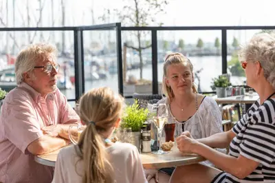 a group of people sitting at a table in a restaurant at Marinapark Volendam in Volendam