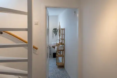 a hallway with a stairway leading to a bathroom at Appartement aan Zee in Noordwijk aan Zee