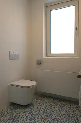 a bathroom with a tub and a toilet and a window at Appartement aan Zee in Noordwijk aan Zee