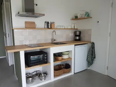 a kitchen with a sink and a microwave at De Duinlopers - Studio appt Bries - Strand, duinen en nabij cultuur steden in Castricum