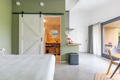 a bedroom with a sliding barn door and a table at De Duinlopers - Studio appt Bries - Strand, duinen en nabij cultuur steden in Castricum
