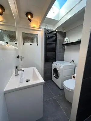 a bathroom with a sink and a washing machine at Zandrijk in Egmond aan den Hoef