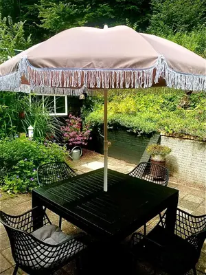 a picnic table with an umbrella on a patio at Zandrijk in Egmond aan den Hoef