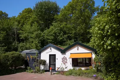 a small white house with an orange and black roof at Zandrijk in Egmond aan den Hoef