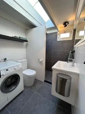 a bathroom with a washing machine and a sink at Zandrijk in Egmond aan den Hoef